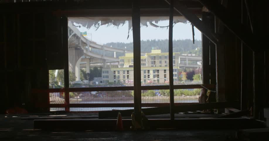 A tattered awning blows in the wind outside a window