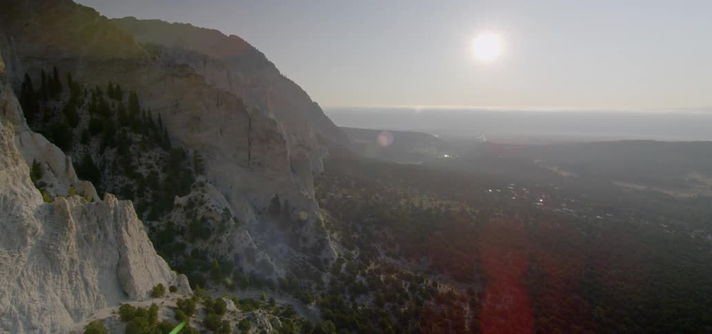 A large mountain has trees all around it's base