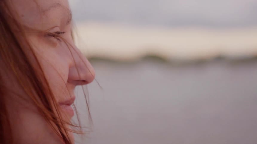 A woman smiles as she looks out over the lake