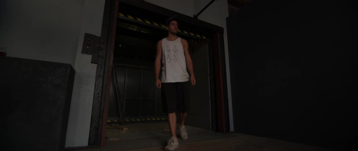 Man lifting up a gate and walking down the hall