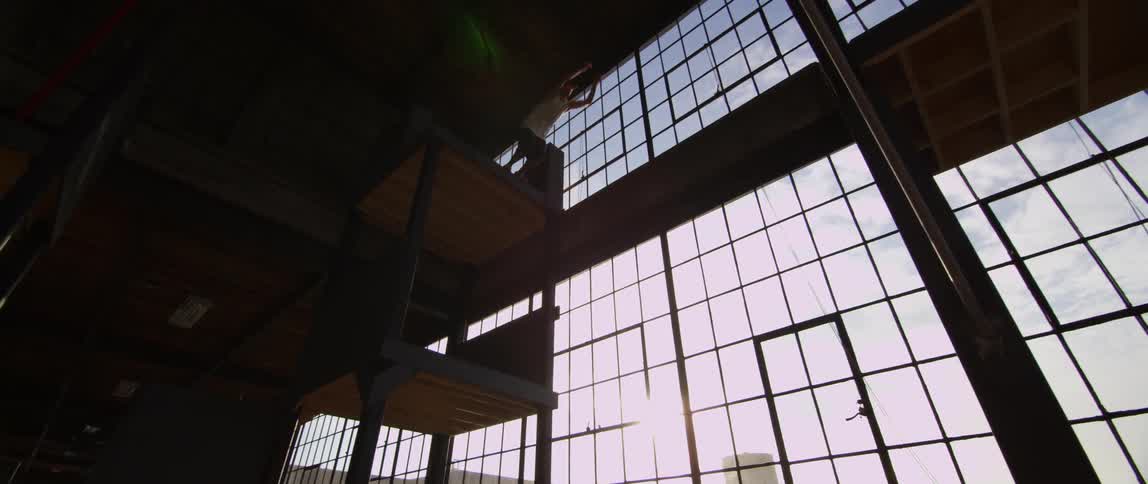 A white man jumps across a obstacle course inside of a large building