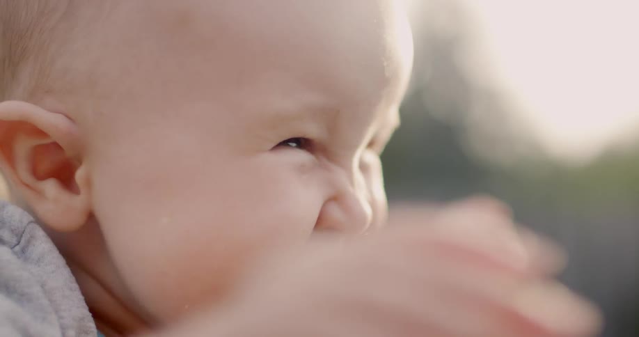 A woman holds a laughing baby outside