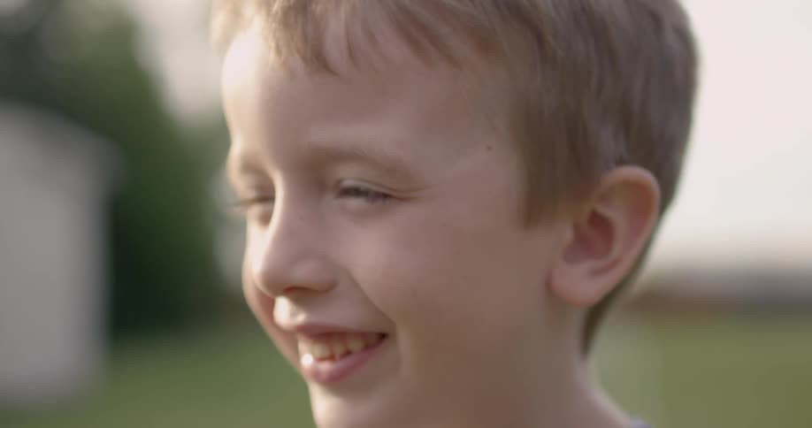 Smiling child blinking in the sun