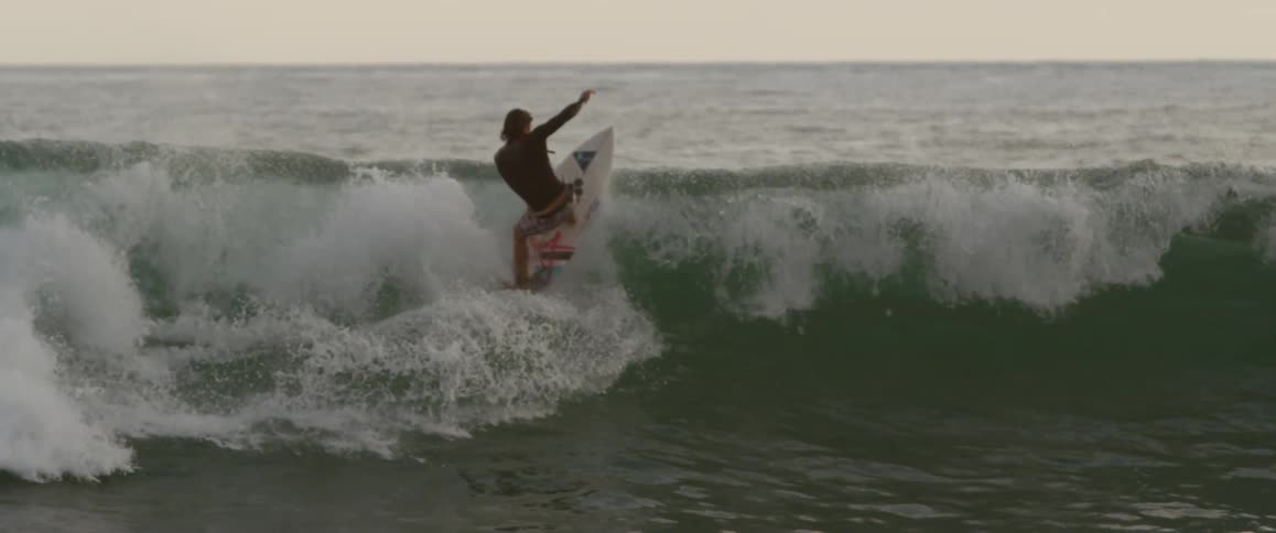 A man surfs in the evening