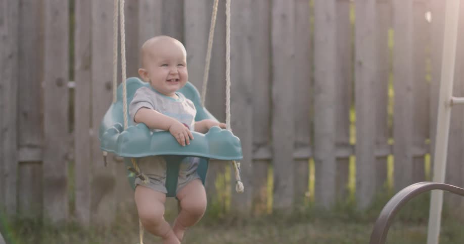 A baby is smiling in the swing