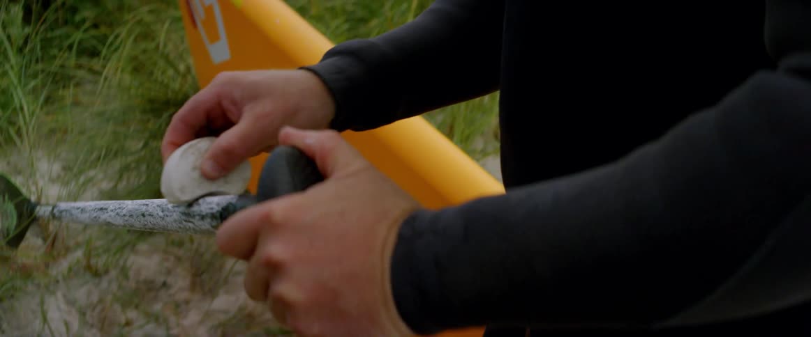 A man waxes a paddle