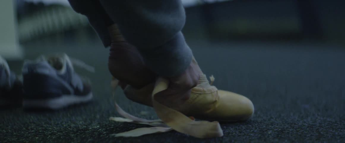 A ballet dancer puts shoes on