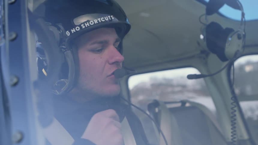 A helicopter operator puts his helmet on