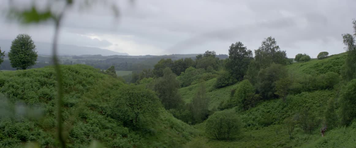 Storm clouds hang over hills on a tropical island