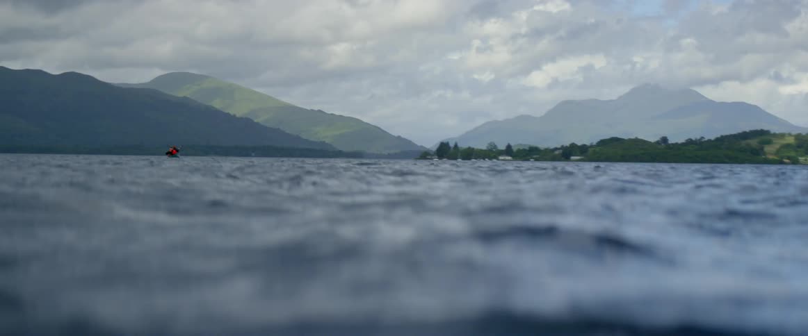 A few people are canoeing out onto a lake