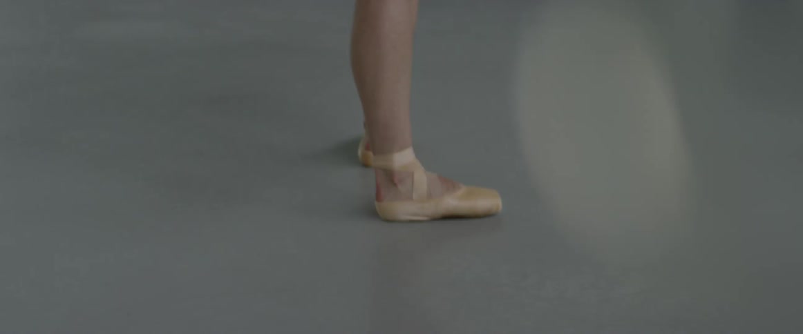 A ballet dancer walks in a studio