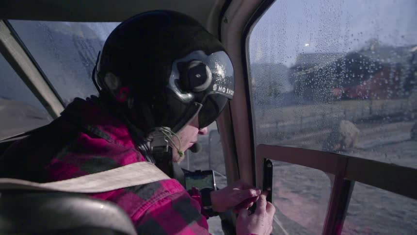A helicopter operator closes the window