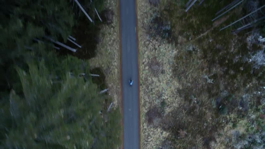 A bicyclist rides down a mountain road
