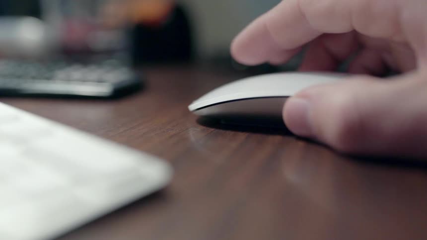 A man uses a mouse on a desktop