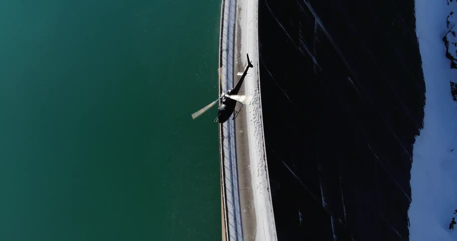A helicopter takes off from a snowy surface