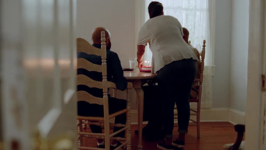 A man is brought a birthday cake at a table