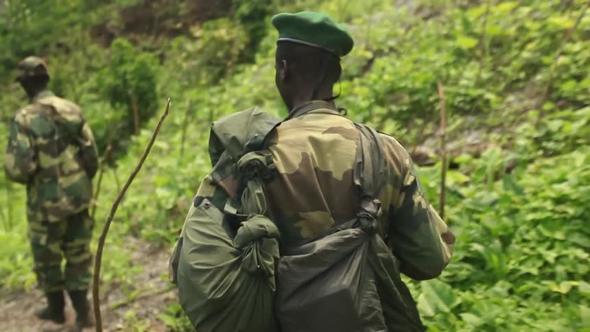 Group of african soldiers walking on a path through a forest