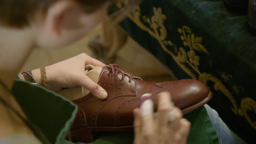 Boy applies polish to a shoe