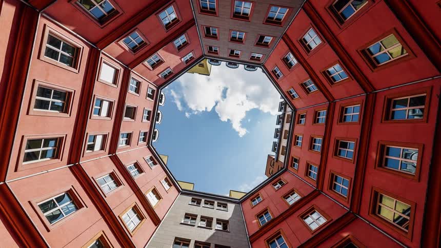 An octagon building is being filmed from the middle looking up towards the sky
