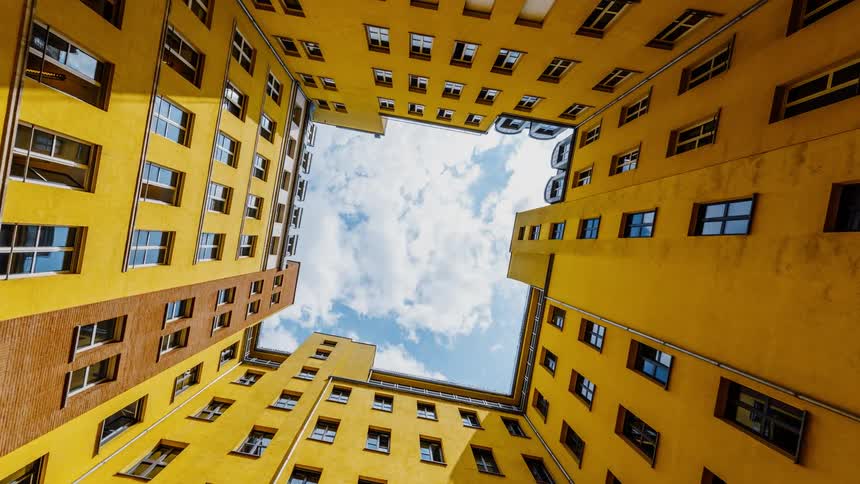 Clouds float over a tall city building