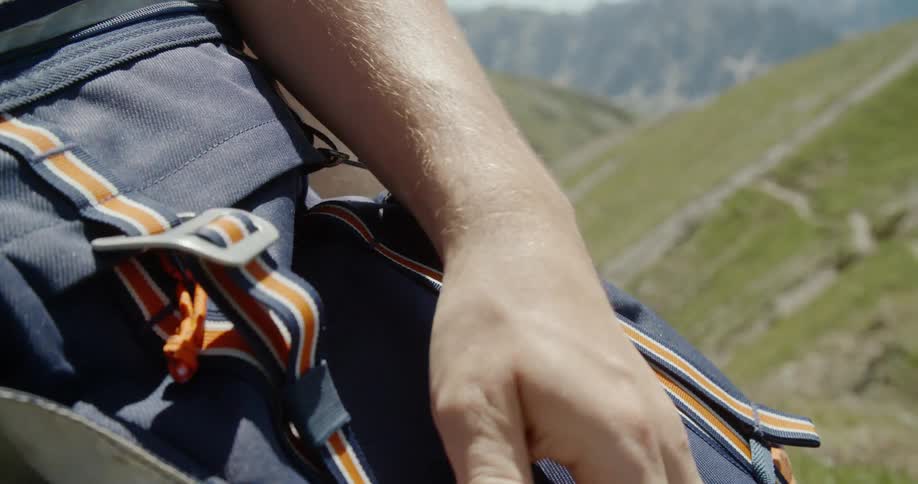 A man adjusts straps on a backpack