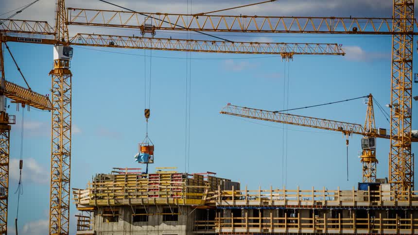 Men build a building using machinery