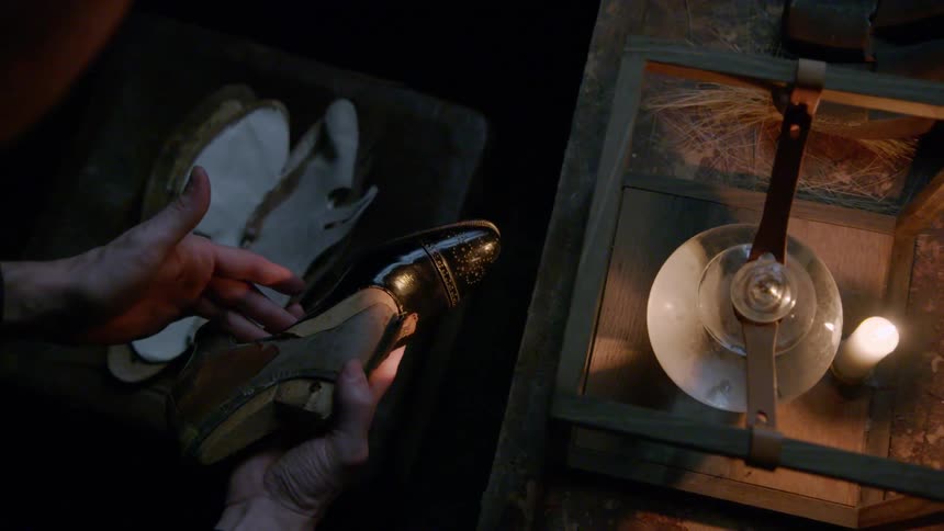 A cobbler inspects a shoe