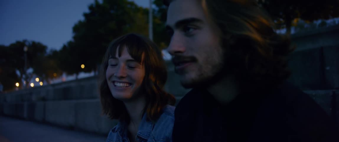 Man and woman laugh outside at night