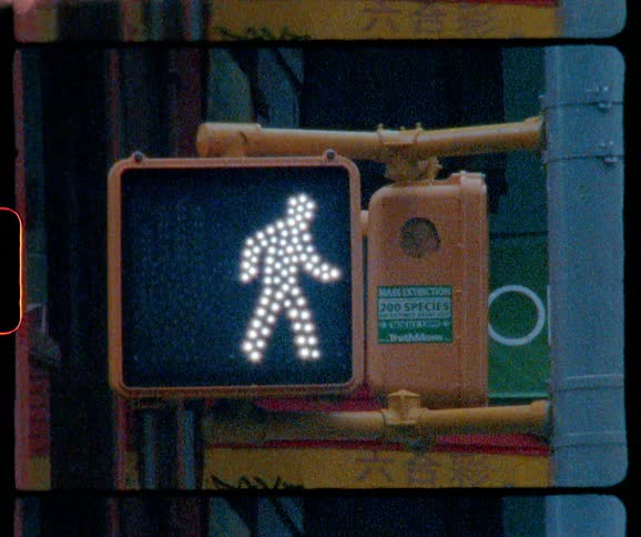 A crosswalk sign changes from stop to cross