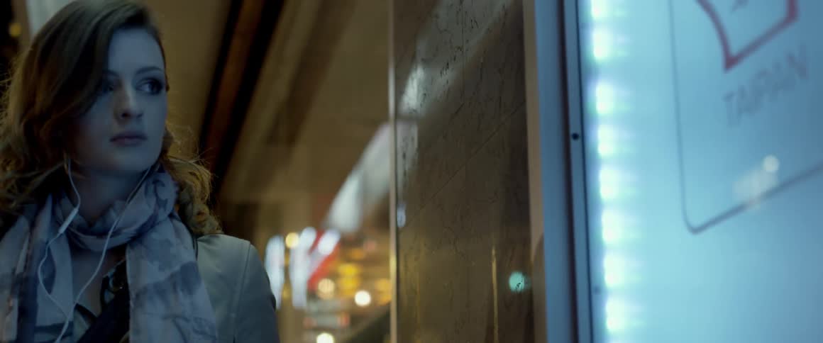 Woman standing in a doorway on a city at night