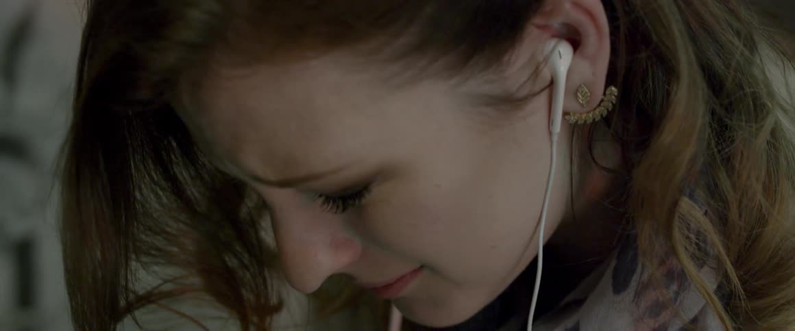 Woman cries while wearing headphones
