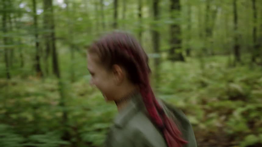 Woman smiles and jogs through the woods