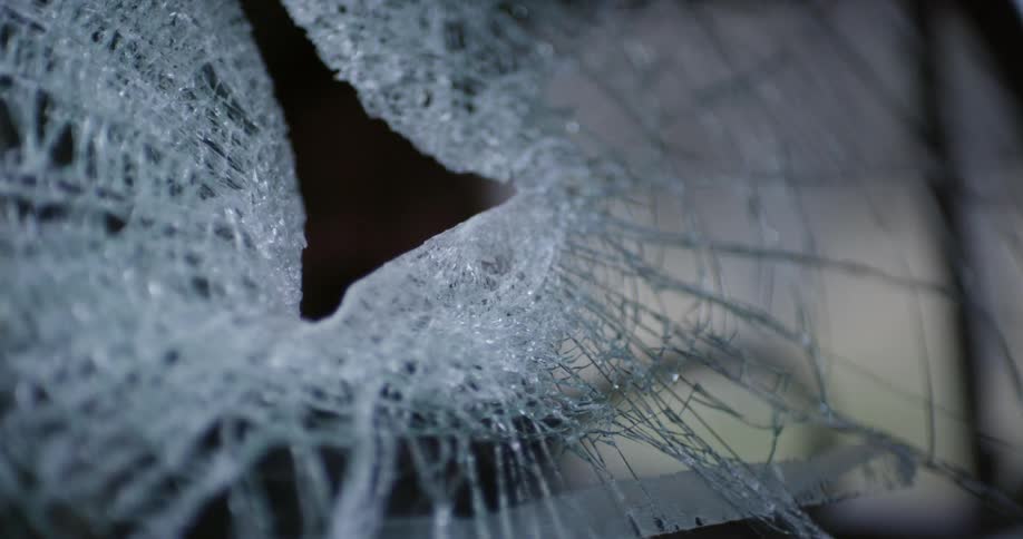 A truck with a smashed windshield is shown close up