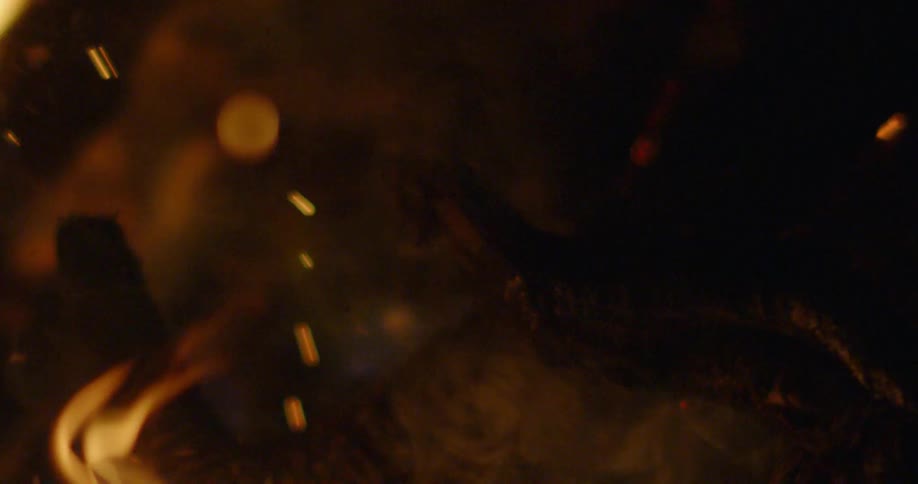 The campfire is burning with sparks all over at night