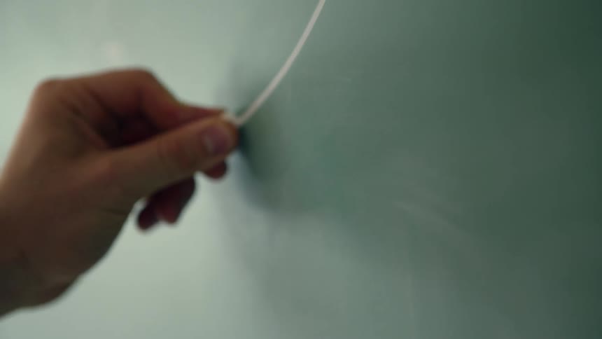 A man is drawing a something on a chalkboard