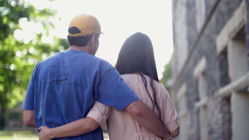 A couple walking beside a building