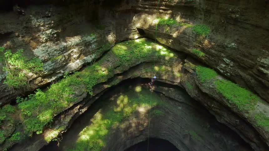 A rock climber climbs up a cavern