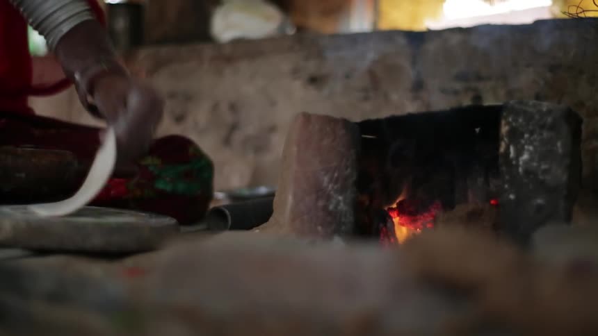 A woman using a rolling pin to roll out dough