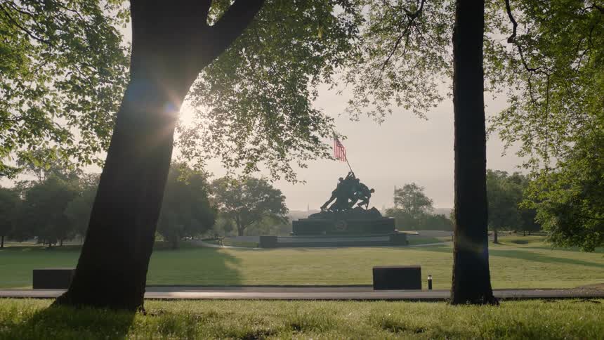 A war monument is shown in the distance of a park