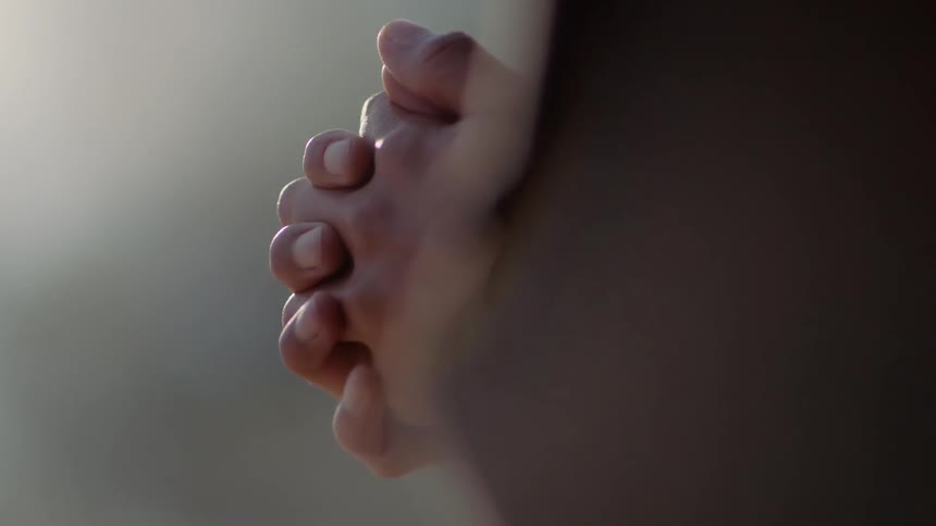 Someone is praying with their hands together