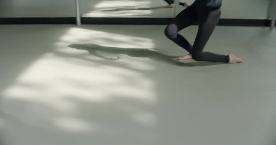 A dancers shadow is reflected on the floor