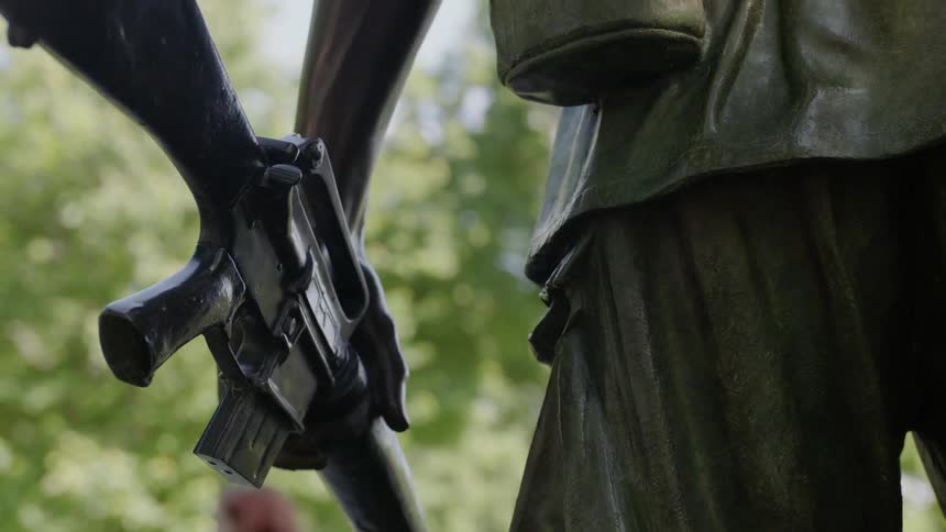 A military memorial statue holds a rifle