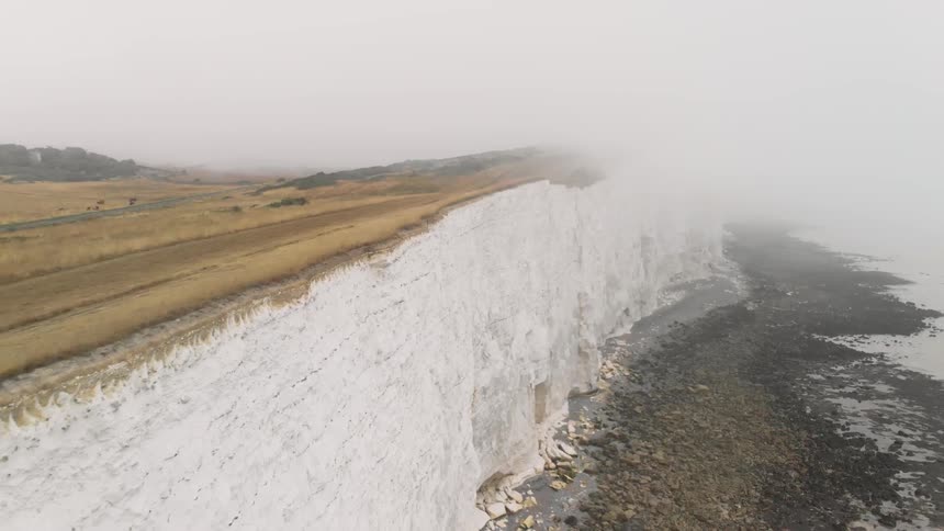 Fog covers a steep cliff