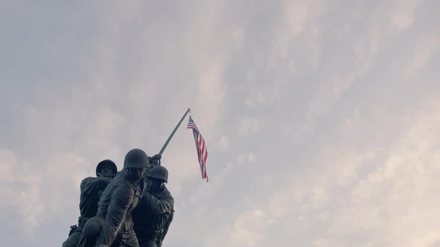 A close up of a soldier monument as the sun sets