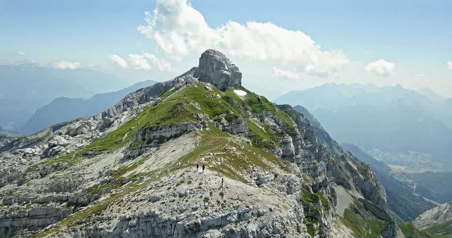 A rocky mountain is shown with people on top