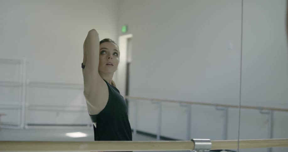 A woman is doing an intense dance in front of a mirror