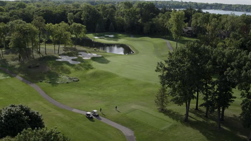 Golfers walk on a golf course