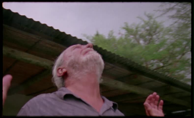 Man outside and lifting hands while looking at the sky