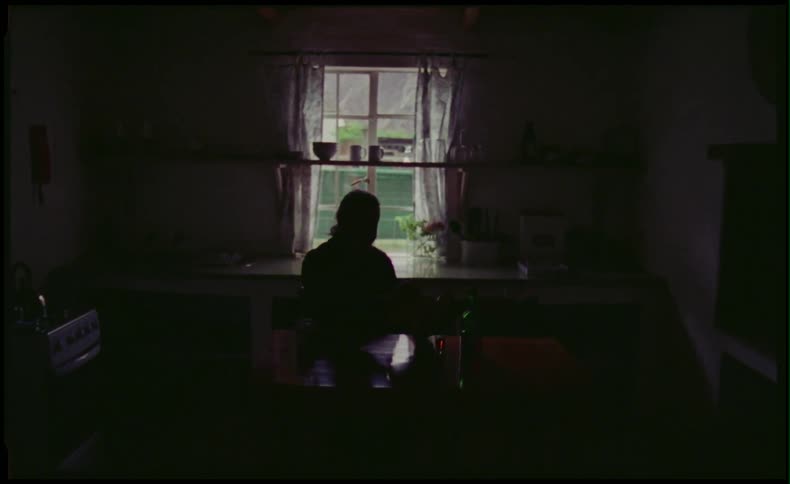 Person sitting in dark room in front of the window