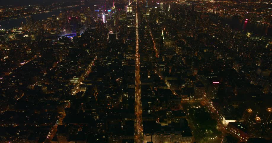 Tall city buildings illuminate the night sky